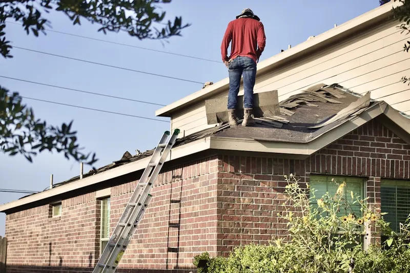 Professional roofer working on a residential roof in Bear Loop